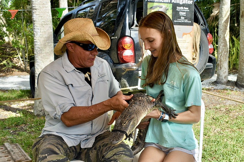 Gator-John Kenyon hands Cringer the alligator over to Shelby Williamson, 13.