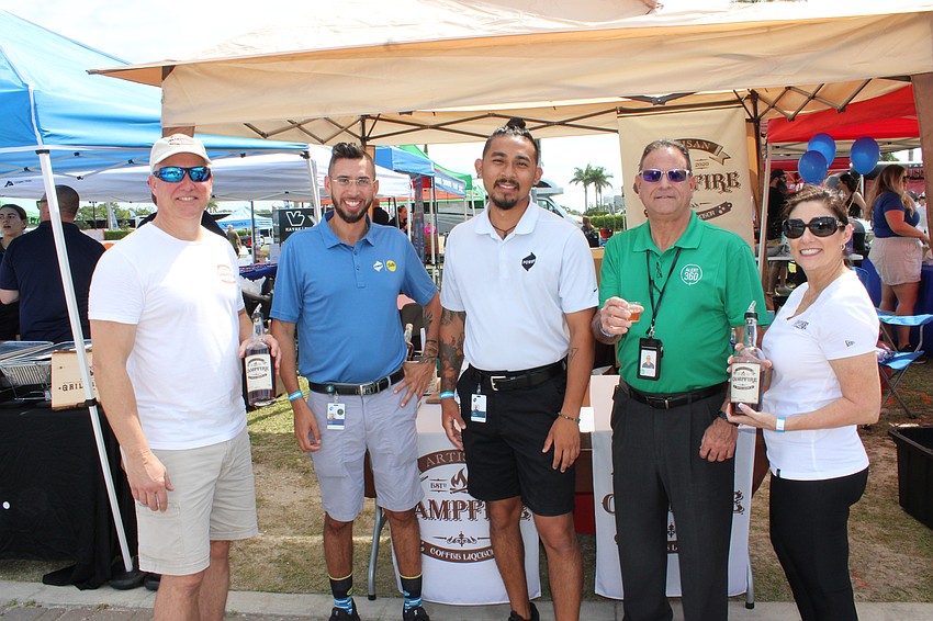 Jon Kleiber (left) and Brenda Kleiber (right), the owners of Campfire Beverages give Tampa's Austin Aletriz, Tampa's Jake Lopez and Bradenton's Frank Grooms a taste of Campfire Coffee Liqueur at My Hometown Fest.