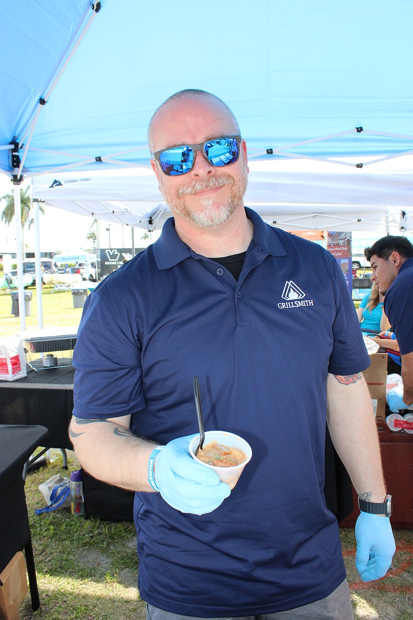 Grillsmith Operations Director Benjamin Horstman serves up an order of Cajun shrimp and grits at My Hometown Fest. 