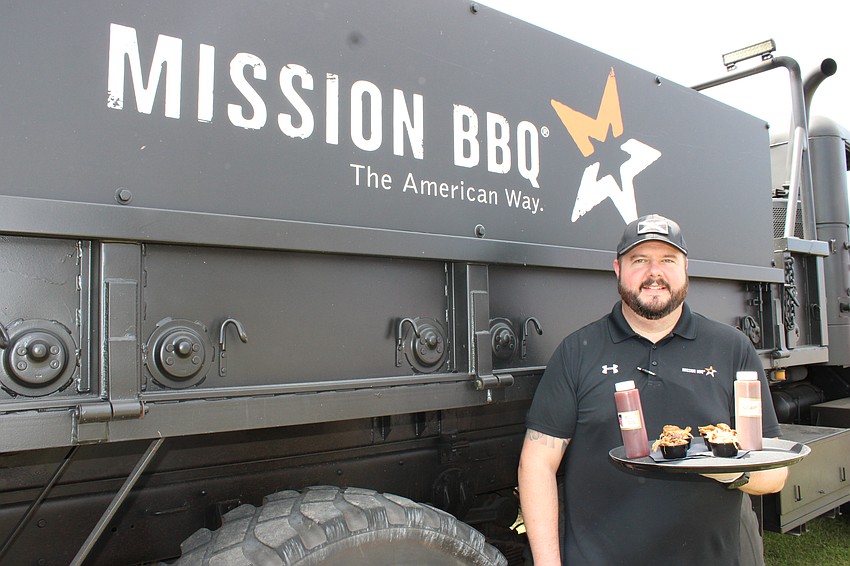 Mission BBQ Area Director Nick Conner is handing out pulled pork and chicken at My Hometown Fest. Mission brought along the 5-ton military vehicle, Bam Bam, to the festival as well.