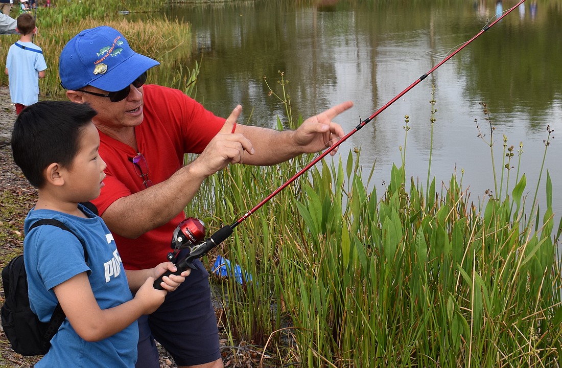 Bradenton's Vincent Wang gets some tips from Robert LaVopa of the Lakewood Ranch Anglers Club during the annual Youth Fishing Tournament in 2023 at Lake Uihlein.