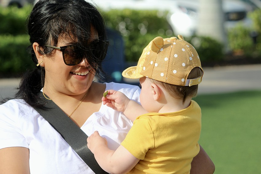 Maximilian Mazias tries to feed a leaf to his nanny Diana Arellano.