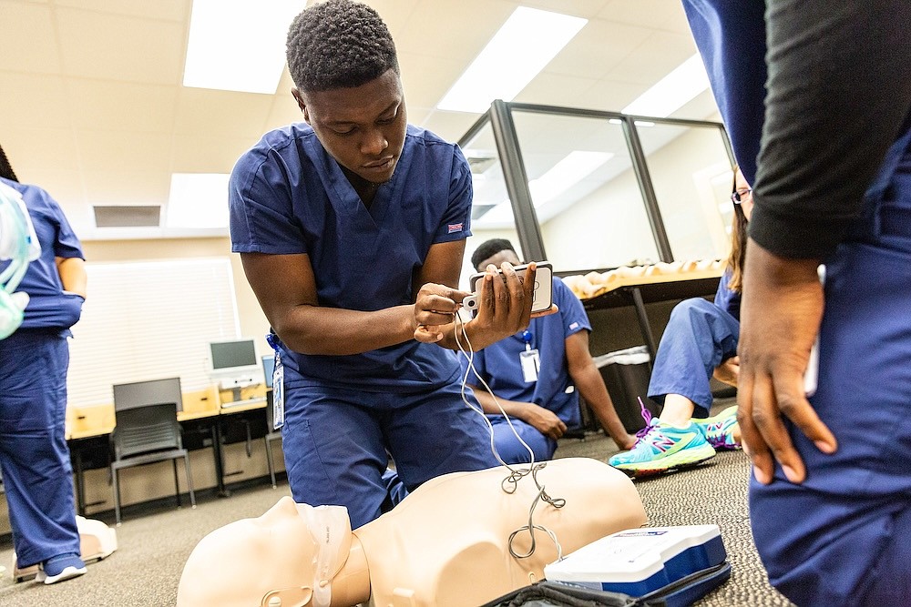 A student uses a medical device on a dummy at St. Petersburg College. The college says it will expand its workforce innovation programs at the Hub.