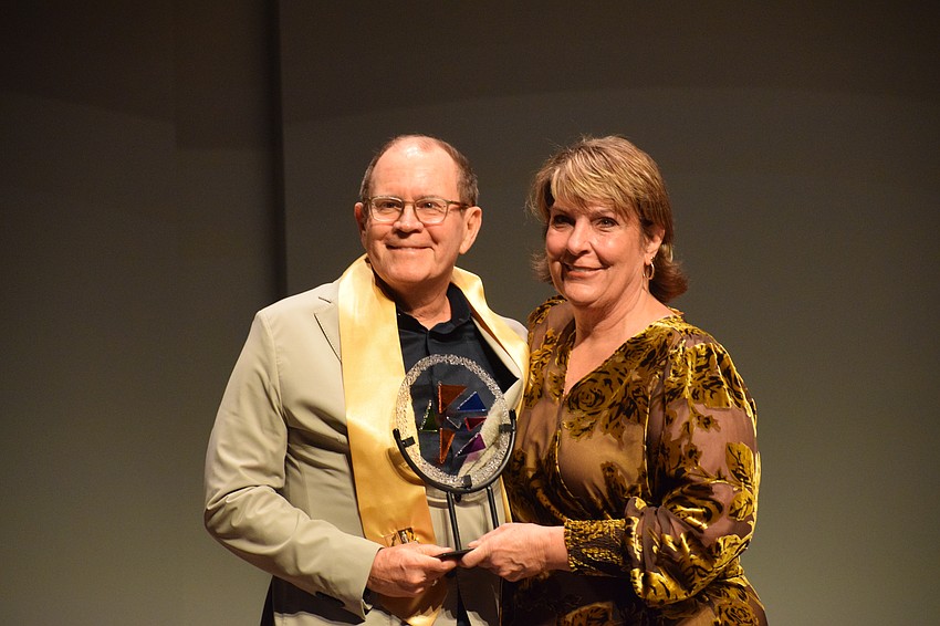 Dan Denton accepts the Manatee Arts Education Council Distinguished Arts Alumni Award from Dudley Leigh.