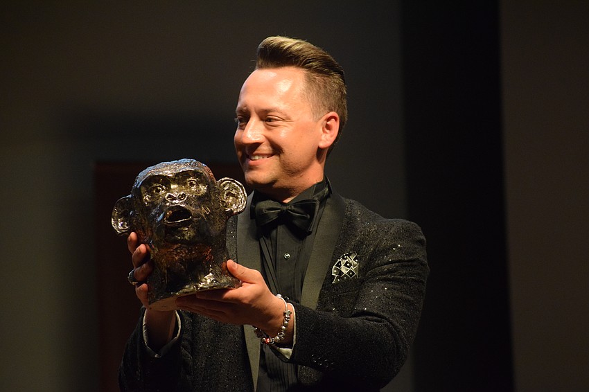 Jeramiah Bowman, the chairperson of Manatee Arts Education Council, shows the audience Manatee High School's Israel Samedi's work for the live auction. It was sold for $400.