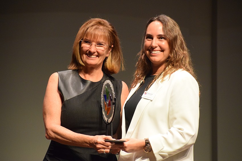 Karen Corbin, the executive director of Realize Bradenton, accepts the Dr. Larry Thompson Arts Education Advancement Award from Chelsea Garner-Ferris with Ringling College of Art and Design on behalf of Johnette Isham. Isham died in July 2023.