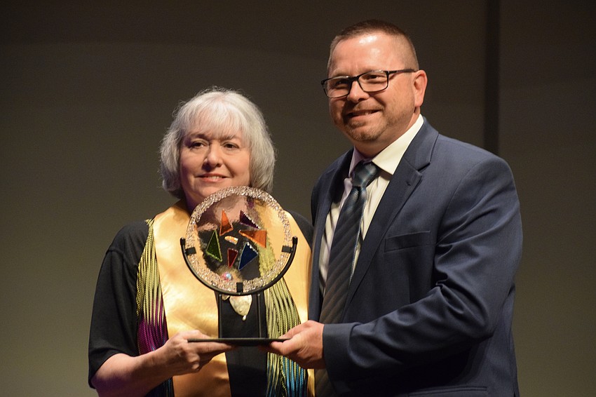 Una Jones, who founded Manatee School for the Arts, accepts the Barbara Turner Grace Visual Art Education Award from Steven Marshall, who is the principal of Manatee School for the Arts.