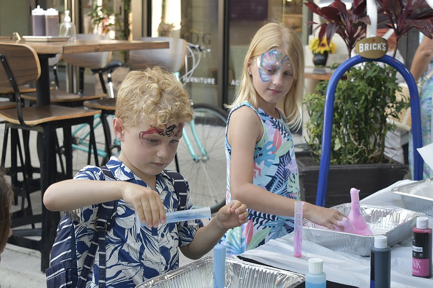 Emory Arthur, 7 and Ellie Arthur, 9 perform a science experiment at the Suncoast Science Center table.