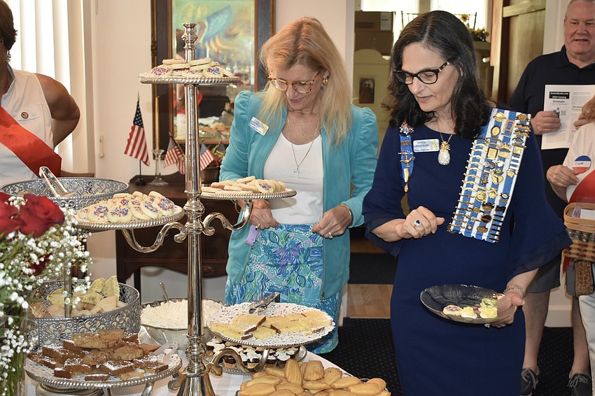 Katie Campbell, regent of the Mary Virginia Cabell Chapter of DAR from Maitland, Florida, and Jennifer Lawton Marks, the state registrar of DAR for Florida, peruse treats at the tea table.