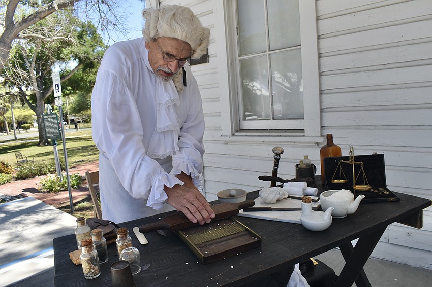 Wallace Hoppe, who played the role of an apothecary, demonstrates pill rolling, a technique used in the past to split material into pills.