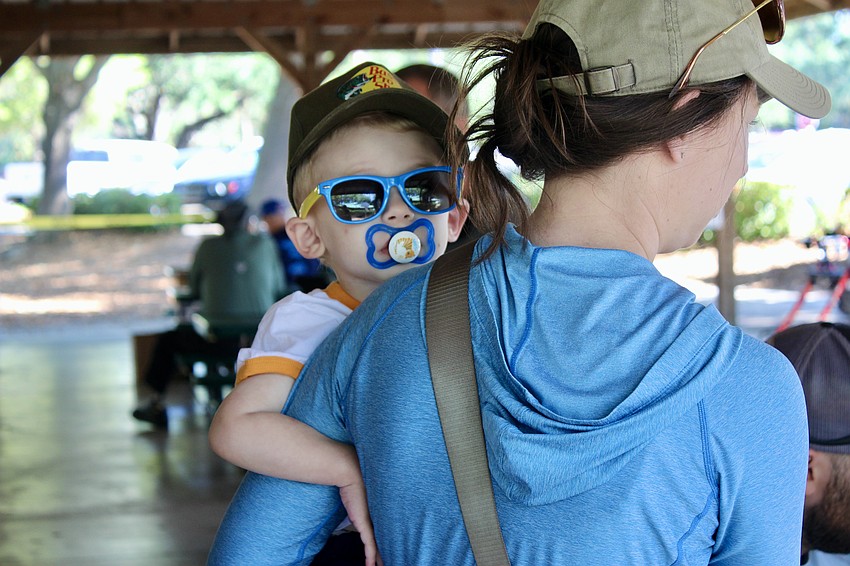 At 2 years old, Austin Loher isn't quite ready to play with hooks yet. He waits with his mom, Meghan Loher, while his sister learns how to fish.