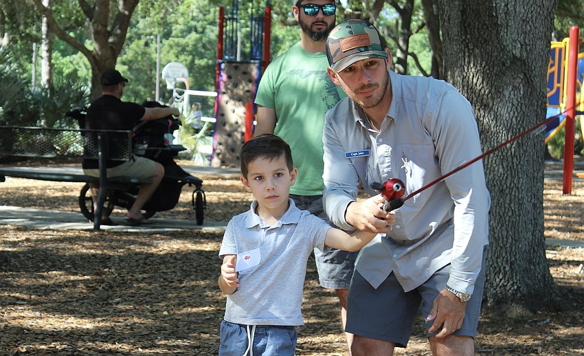 Connor King, 4, learns how to cast a fishing rod from Captain Jake Andrews.