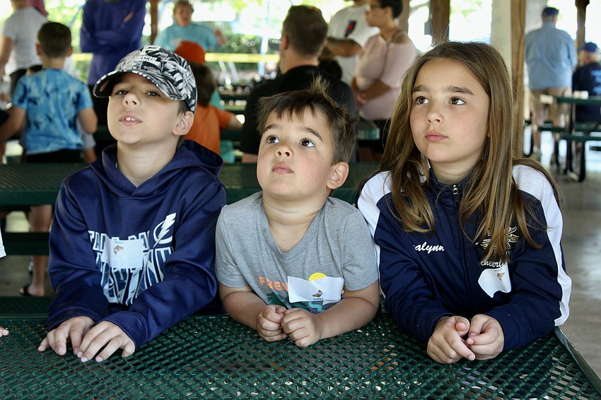 Adrian, Greyson and Evelyn Voica take their turns at the tackle station.