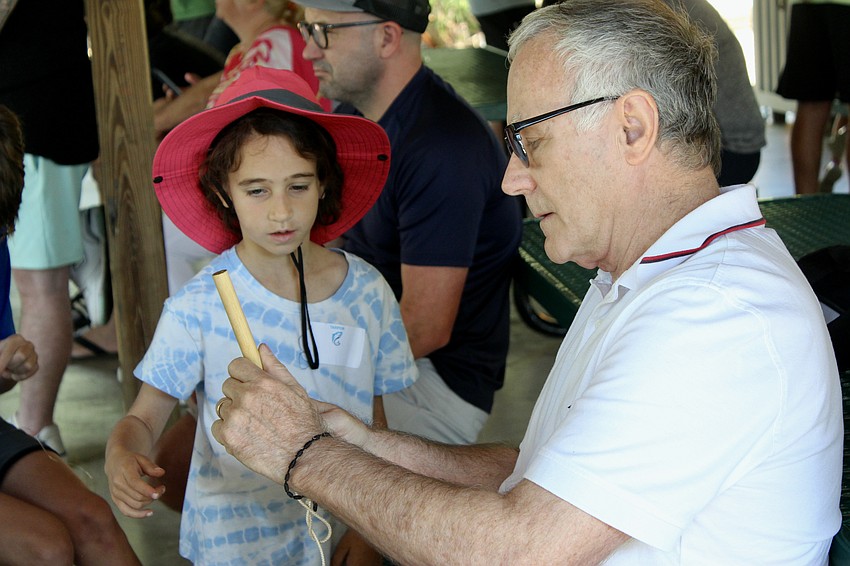 Carol Crow, 7, gets help tying a knot from her grandpa David Crow.
