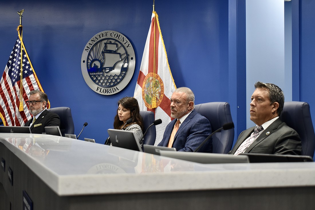 Commissioners Mike Rahn, Amanda Ballard Ray Turner and George Kruse sit at the dais. Kruse is met with silence on March 12 when proposing call-in comments return.