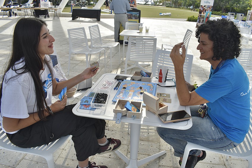 Zainab Saria, an intern with Minoirities in Shark Sciences, plays a board game she created with Park Guest Experience Director Diana Shaheen.