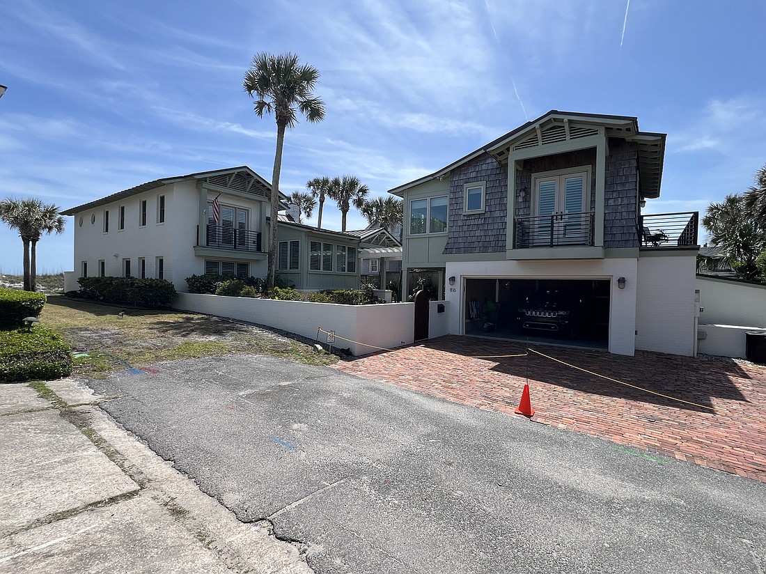 Oceanfront two-story home features four bedrooms, three bathrooms, office, deck, porches, courtyard, guest cottage and dune walkover.