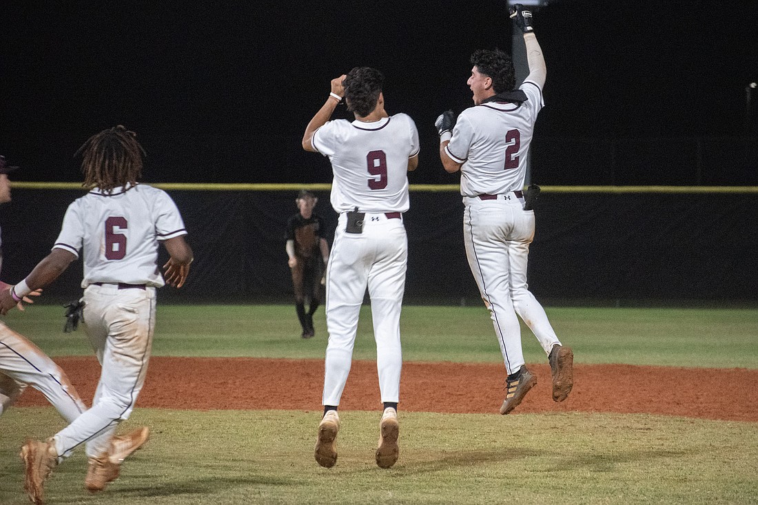 Braden River High baseball juniors Jacoby Cox (6) and Nick Curbelo (9) celebrate with junior Uriel Barrios (2) after Barrios' game-winning RBI against Lakewood Ranch High on April 11.