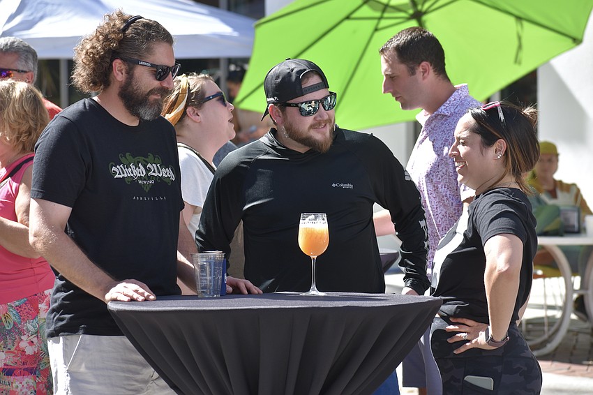 Cory Anderson, Nathan Elliott and his wife Rena Elliot, a 99 Bottles employee, enjoy socializing.