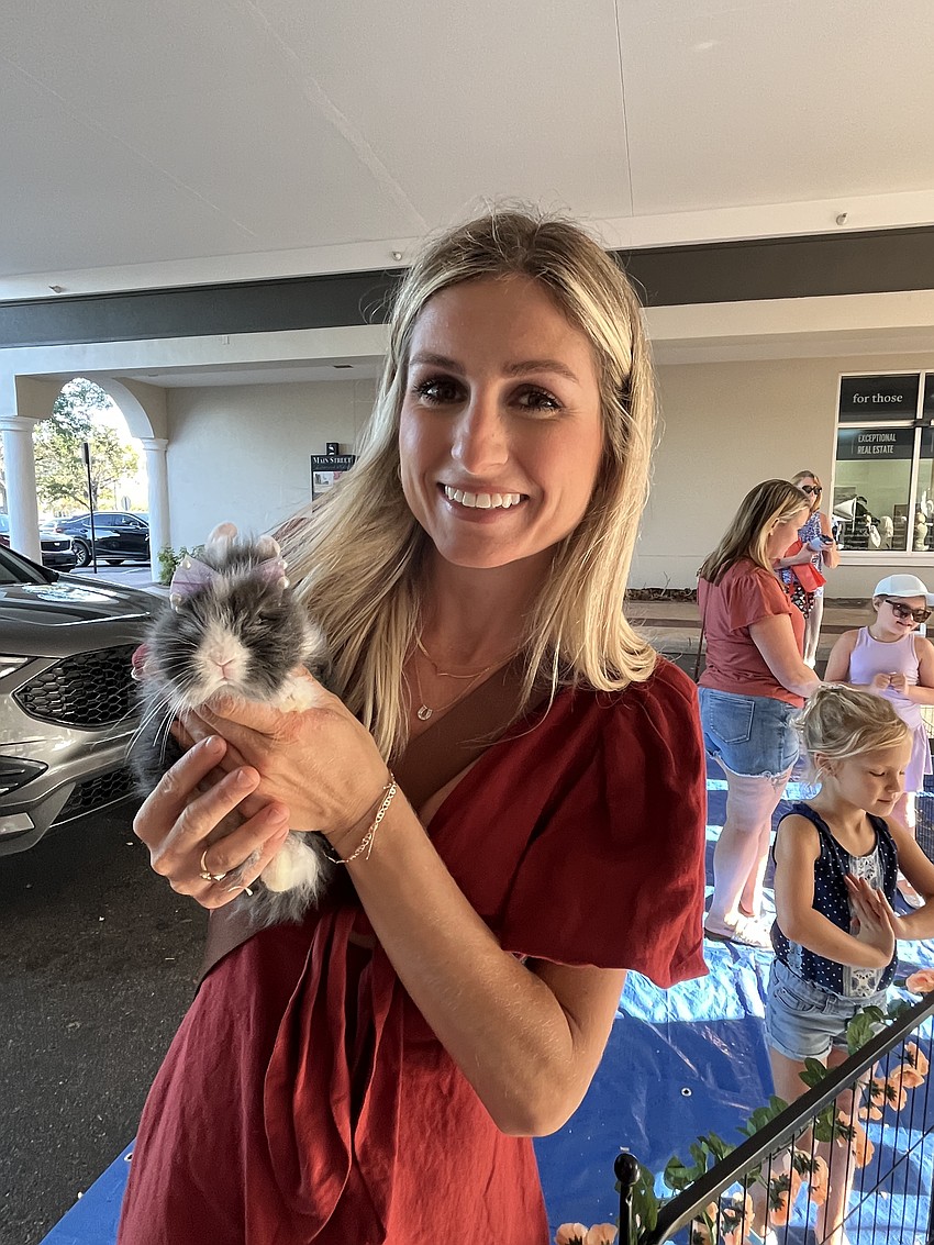 Jaclyn Pearson, the owner of Happy Hooves Mobile Ranch, allows people to interact with Freckles, a bunny out on its first outing after being born a few weeks ago.