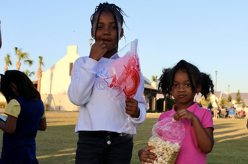 Raelyn and Rian Bell have a snack while waiting to have their faces painted.