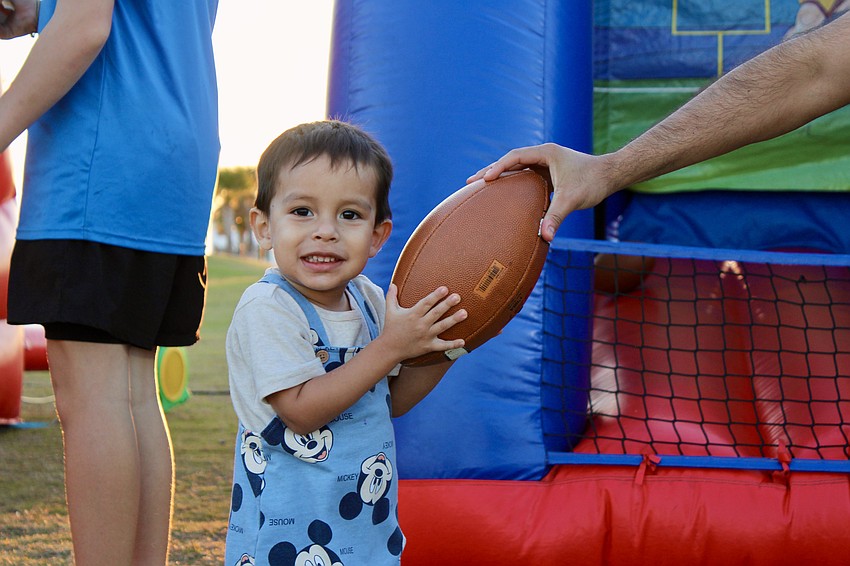 Stefano Flores, 2, practices throwing a football.