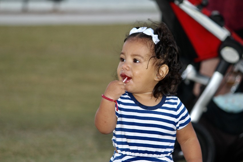 Movie night is all about the popcorn and candy, so 1-year-old Lupe Medina sucks on a lollipop.
