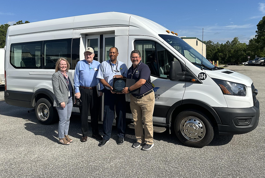 Transportation Disadvantaged Coordinator Summer Jones with Commissioners Dave Sullivan and Andy Dance present driver Richard Briggs with the 2023 Driver of the Year award. Courtesy of Flagler County