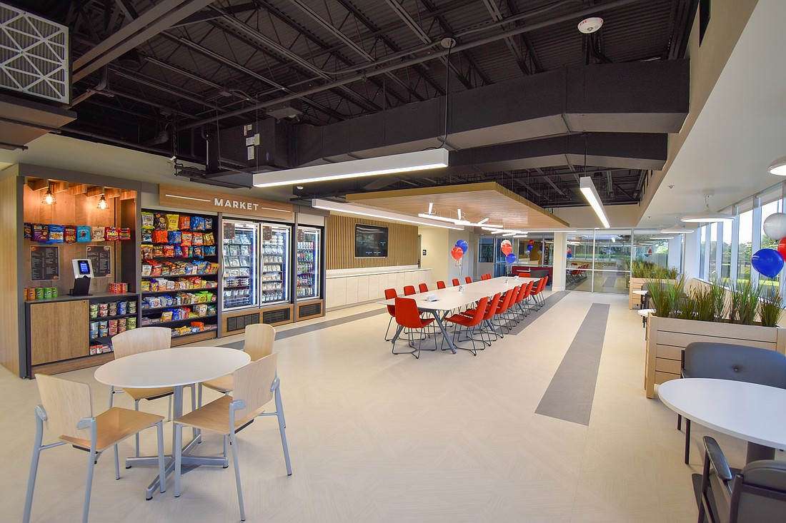 A full view of the Stellar Nutrition Center that shows seating and the market area, where employees can access complimentary snacks and refrigerated meals, grab-and-go items and drinks and check out using a preloaded card via a smartphone app at a kiosk.