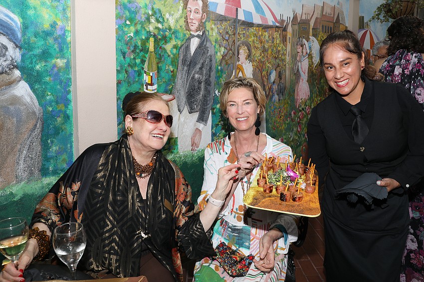 Flora Major and Fellow Anne Patterson enjoy appetizers served by Elizabeth Panduro.