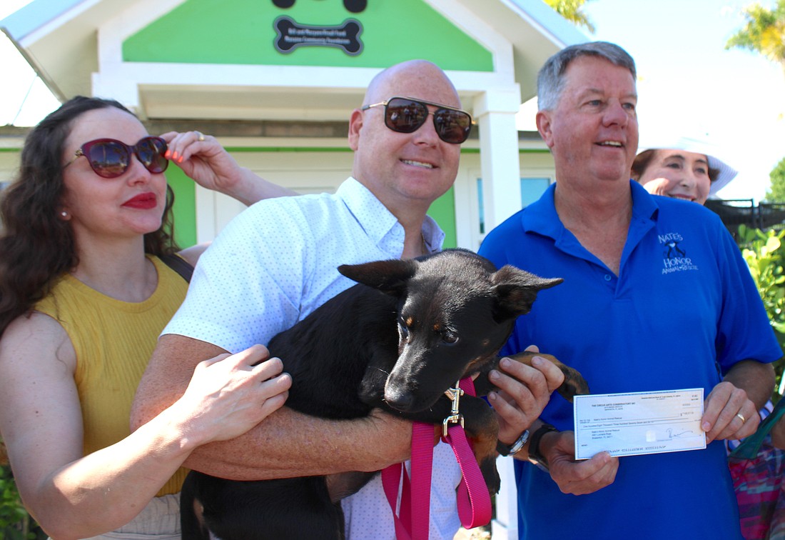 Erendira and Nik Wallenda present a check Wednesday for more than $100,000 to Nate's Honor President Rob Oglesby to go toward the rescue's $14 million improvement program.