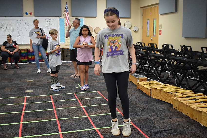 Fourth grader Austin Conner hops along to the music in an African hopscotch.