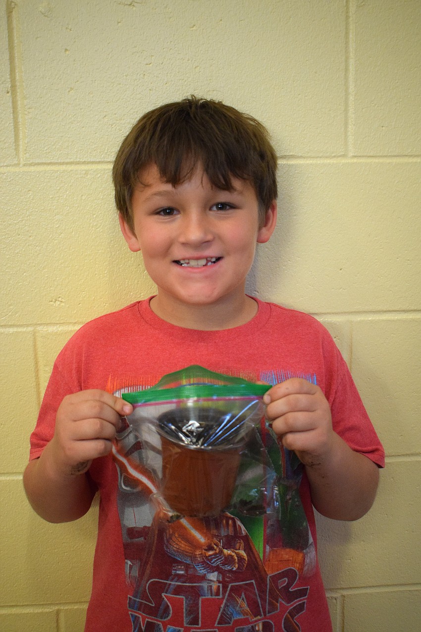 Second grader Calen Magnant is excited to see his plant grow. He says the plant station was his favorite because he likes dirt.