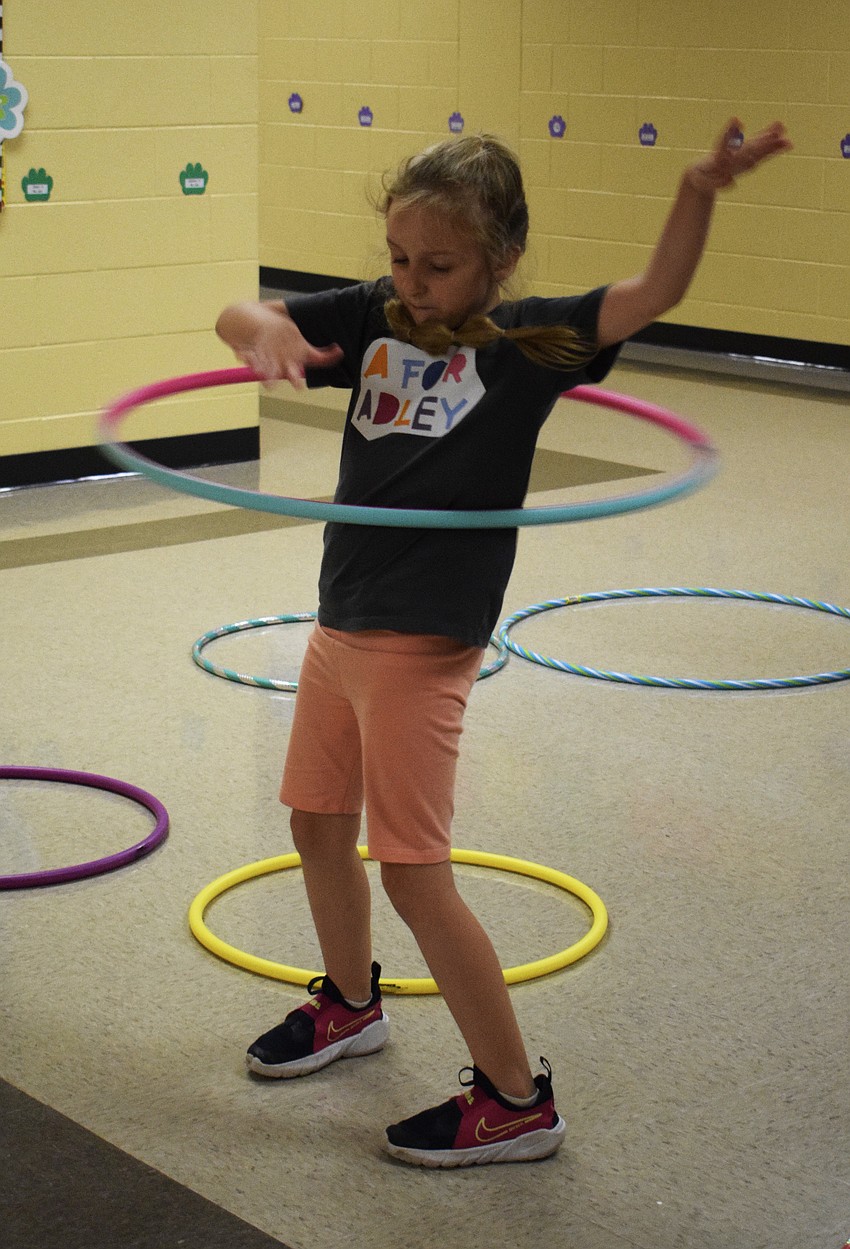 First grader Halle Huber uses a hula hoop to get her heart rate up so she can measure it as part of a STEAM activity.