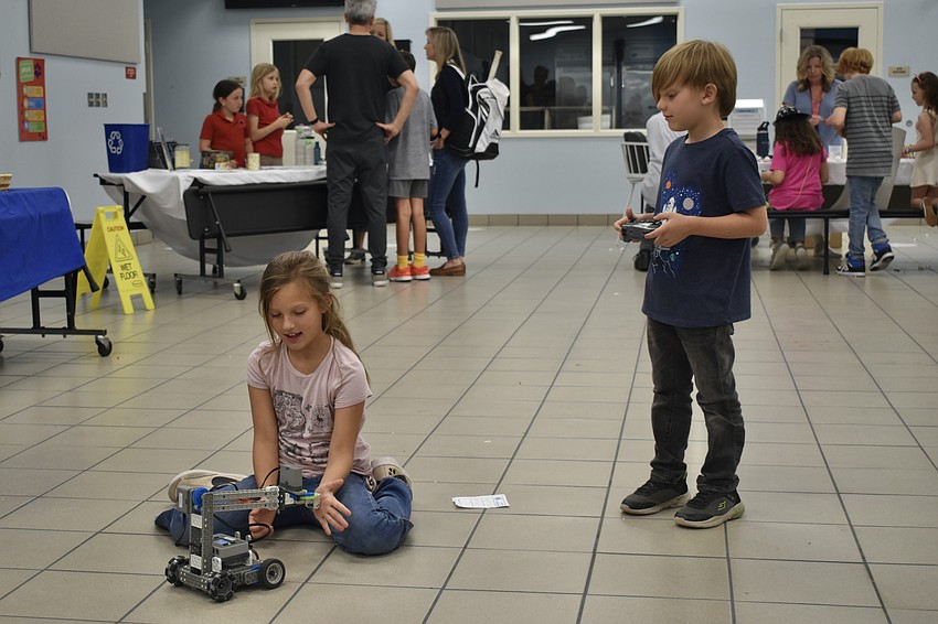 Third grader Grace Eichman and first grader Davin Hicks experiment with a VEX robot.