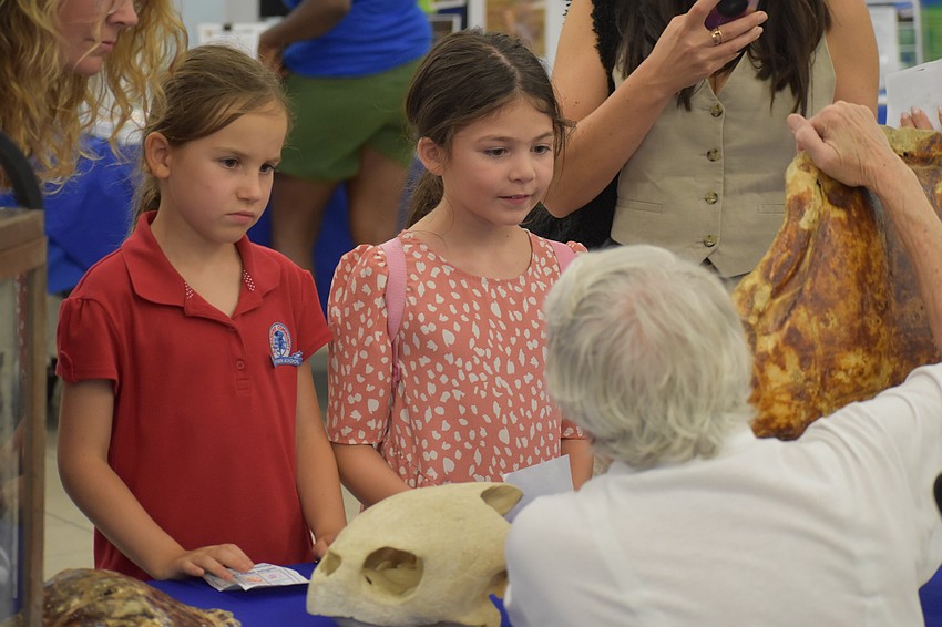 Second graders Sophia Rodinov and Adelaide Hardcastle learn about turtles from Doris Anne Prieur of Mote Marine Laboratory & Aquarium.