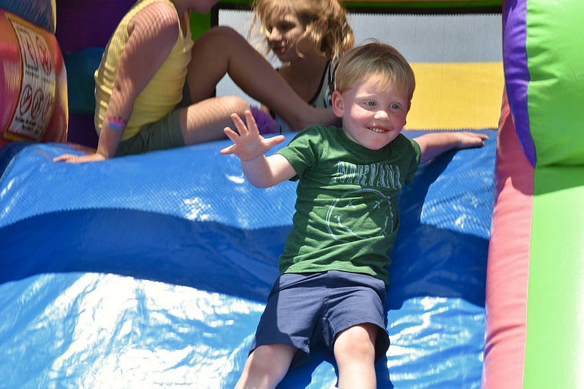 Sarasota resident Jeffrey Dehoff, 3, slides out of the bounce house.