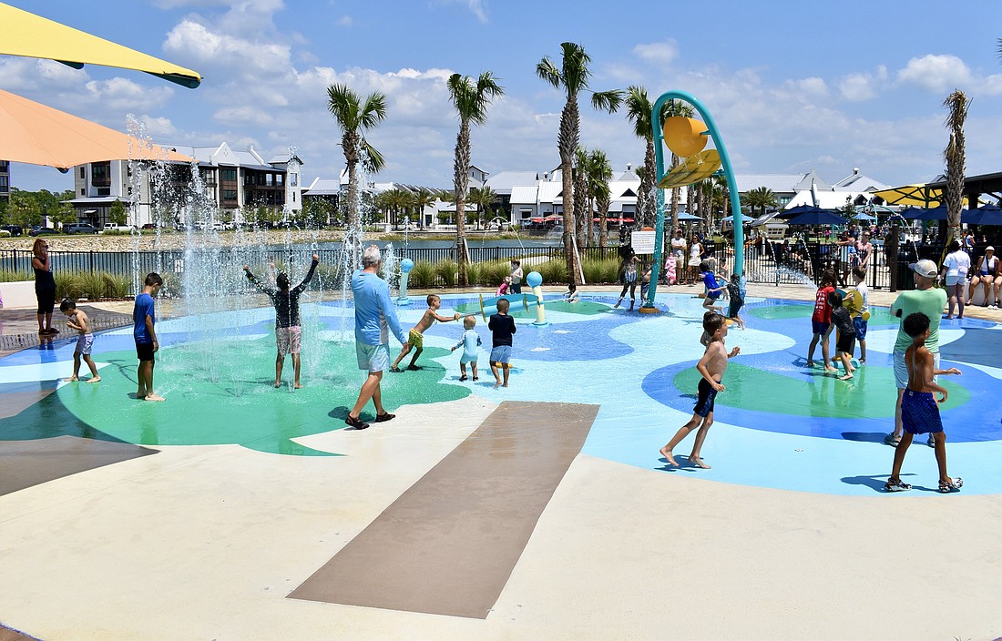 Kids cool down at the spash pad during the grand opening celebration of Waterside Park on April 20.