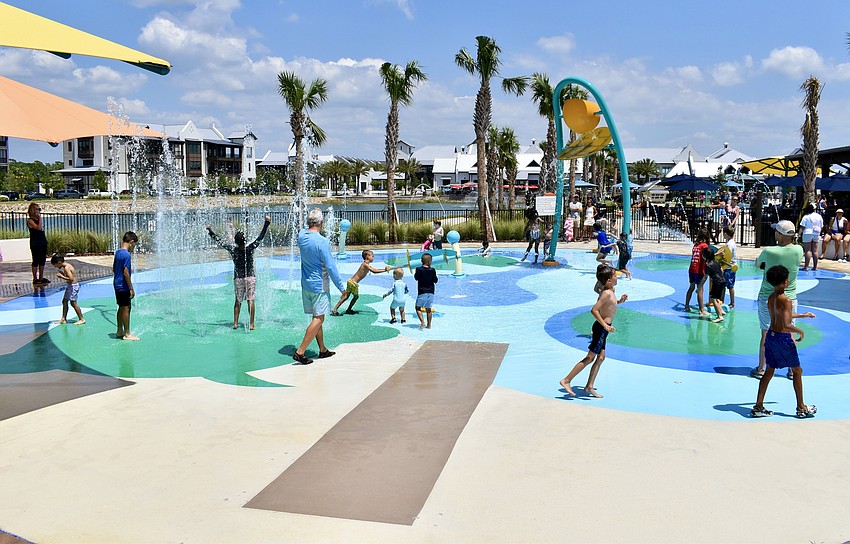 Kids cool down at the spash pad during the grand opening celebration of Waterside Park on April 20.