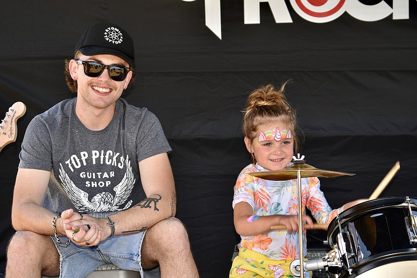 School of Rock instructor Drew Jagos hands over the drum sticks to 4-year-old Gianna Panarella.