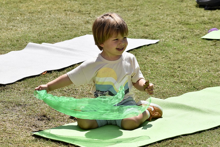Leo McHugh, 2, the son of instructor Jessica McHugh of Wholehearted Education, waves his cloth through the air.