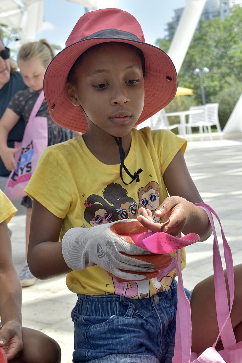 Janeli Griffith, 8, finds a millipede in the soil at Sunshine Community Compost.