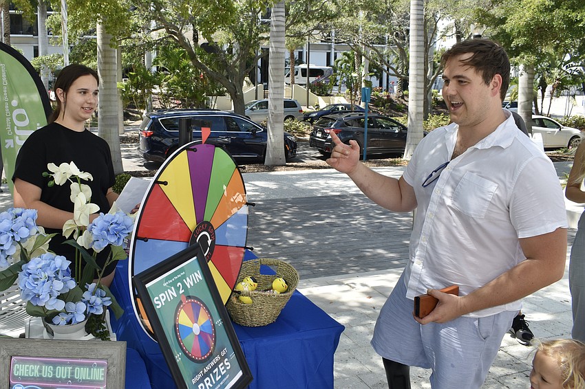 Isabella Pajevic watches as Vlad Ladchuk tries the spinner at Crystal Clean Green Cleaning.