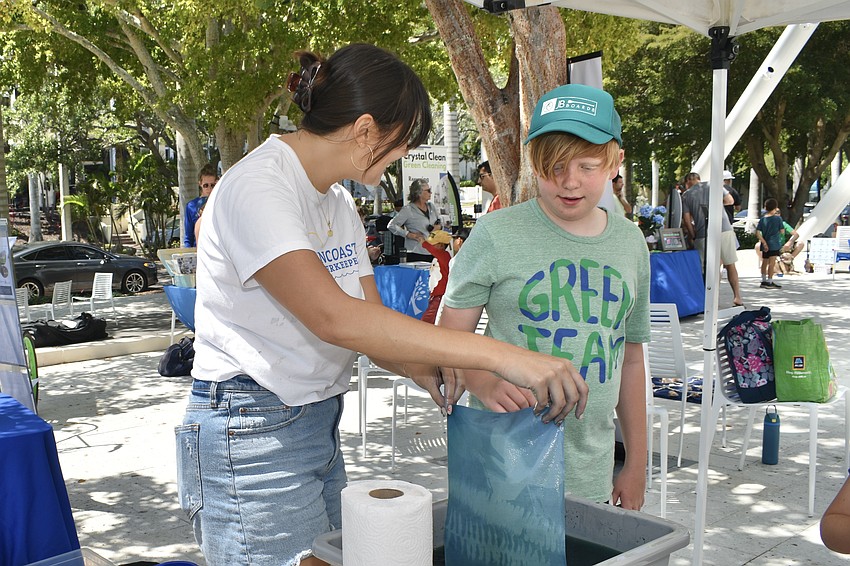 Samantha Wassmer of Suncoast Waterkeeper holds up a finished sun print for Kellen Roth, 10.