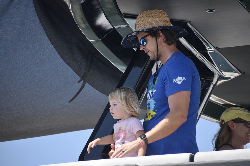 Sofia Marshall, 2, and Victor Marshall get a view of the boat show from an upper deck.
