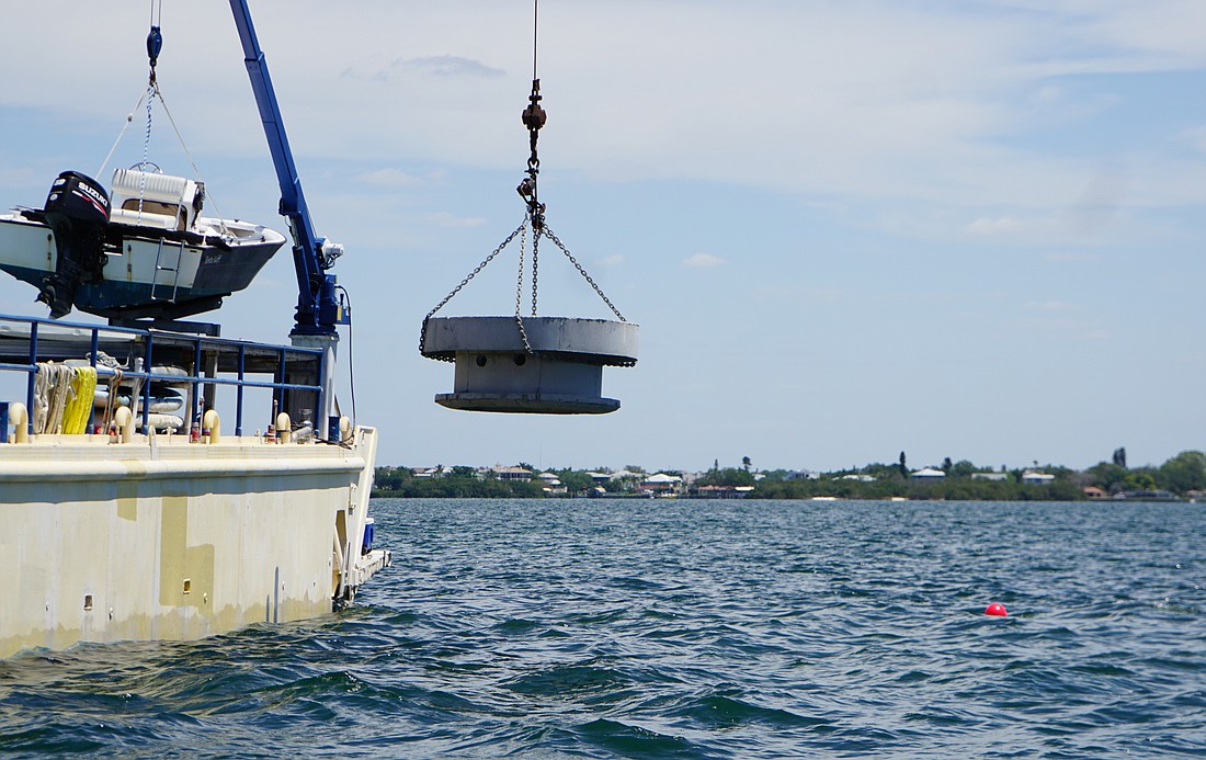 Crews drop a deep-cover reef module into Sarasota Bay.