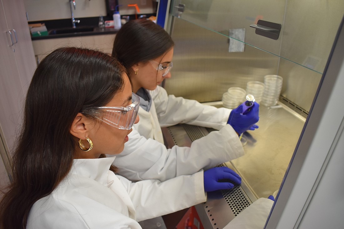 Ianna Guedes and Lucia Moretta add a treatment to their bacteria. The Giving Challenge has helped meet the needs of students at Sarasota High School's MaST Research Institute.