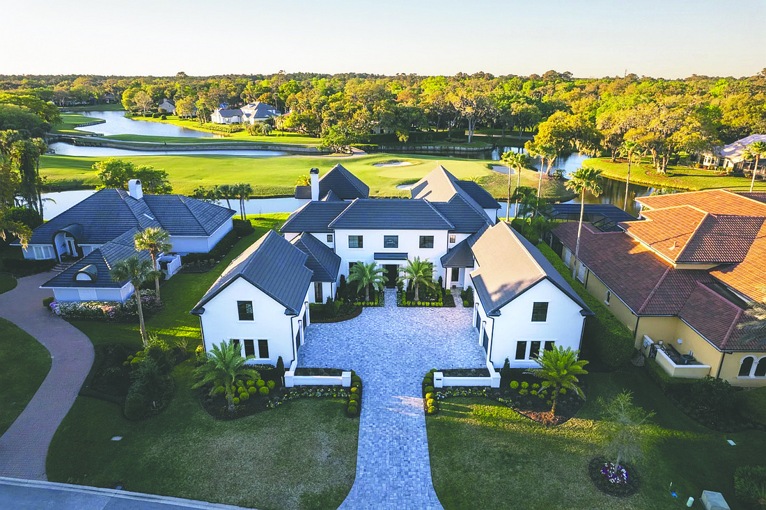 Coastal contemporary two-story home with golf course views features five bedrooms, six bathrooms, office, exercise room, wine cellar, outdoor kitchen, patio and porches, putting green, pool and five-car garage.
