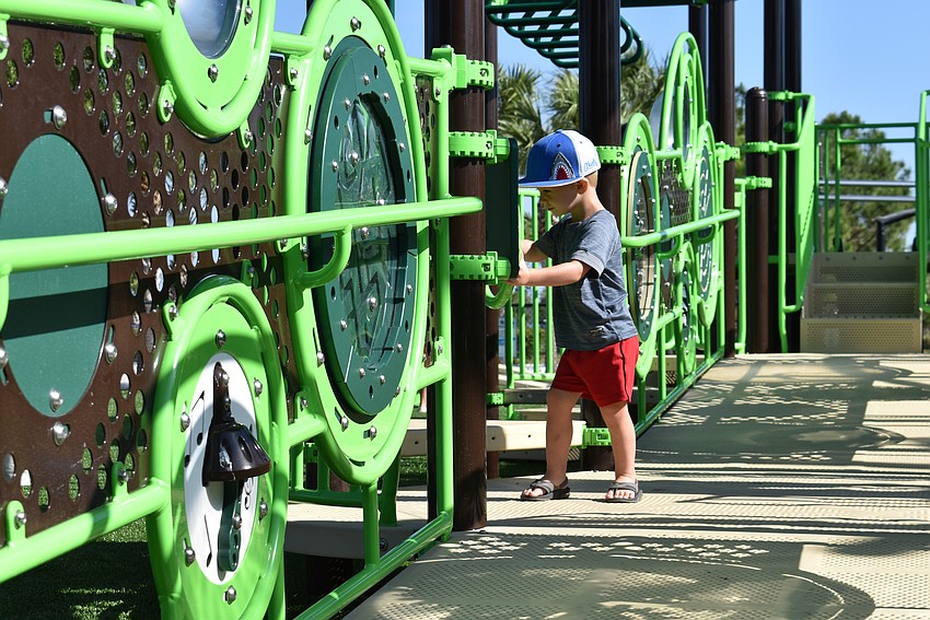 Parrish resident Jeff Kukulka, 2, makes his way through the new playground equipment at Tom Bennett Park.