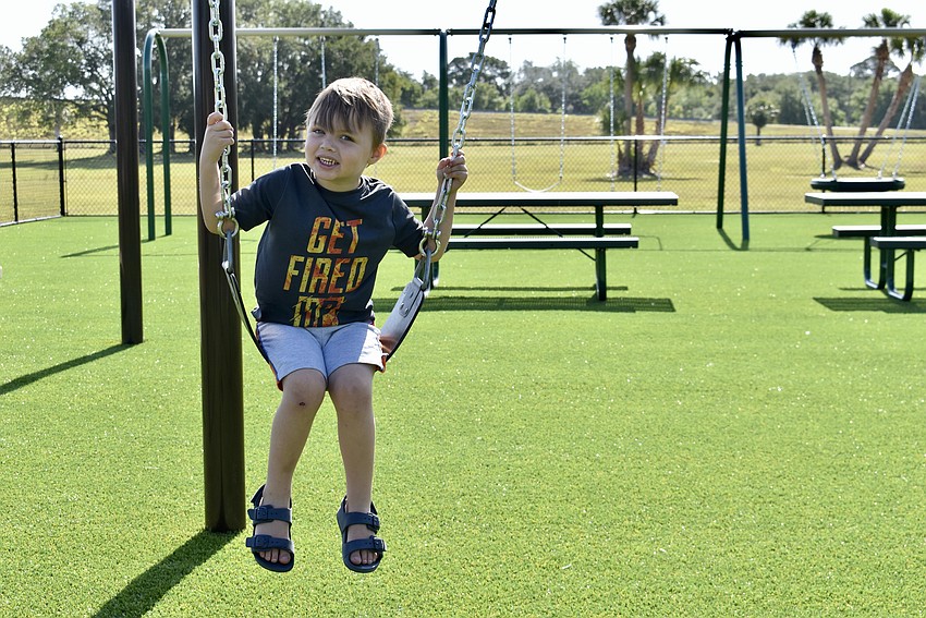 Palmetto resident Liam Dowdy tries out the swings.